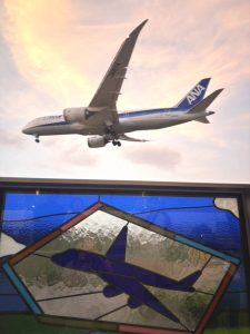 豊中市の企業から寄付された美しいステンドグラスのある展望スペースから見える飛行機